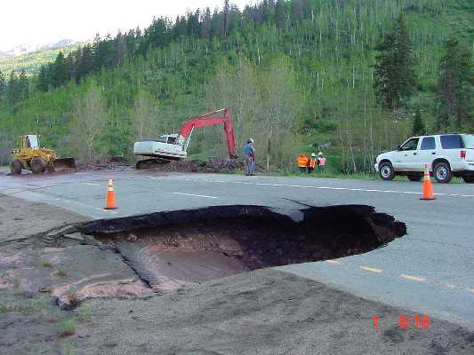 A drainage culvert under the highway collapsed causing water to erode out the soil around it.