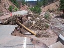 In June of 2006 flood debris clogged a concrete box culvert.  The water eroded out the highway in its search for a new flow path. thumbnail image