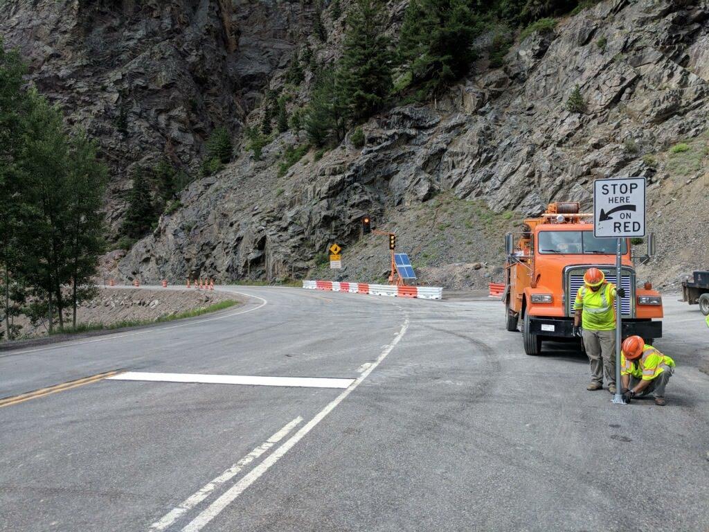 CDOT PHOTO: A CDOT crew sets up signage and portable traffic signals on the north side of US 550 Red Mountain Pass. Motorists are advised to drive with caution as they travel over this high county roadway. Drivers will encounter a one-lane, alternating traffic configuration controlled by the traffic signals about two miles south of Ouray. 