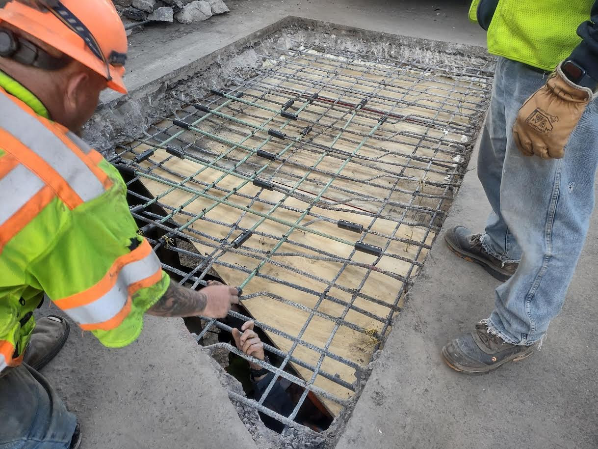 Crews repairing pavement during day detail image