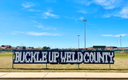 Bulldogs Buckle for Safety with Buckle Up Weld County message installed with fence cups in chain-link fence at University High School in Greeley..png thumbnail image