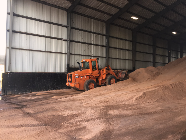 Crews stacking winter materials, solid de-icers