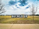 Buckle Up message installed with put-in cups in chain-link fence at John F Kennedy High School in Denver.jpg thumbnail image