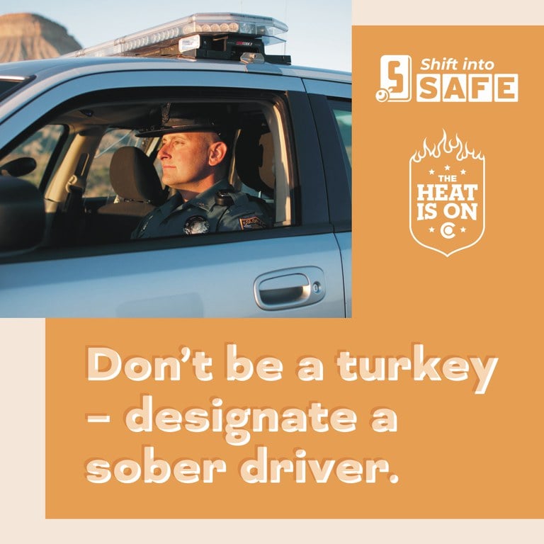 Orange graphic with Shift into Safe logo, The Heat Is On logo and photo of a Colorado State Patrol trooper sitting in the front seat of a patrol car. On graphic copy reads “Don't be a turkey - designate a sober driver.”