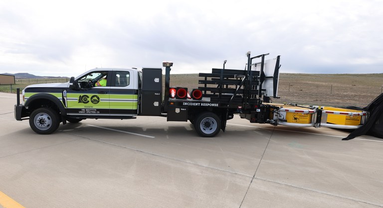 Neon green CDOT Incident Response truck with an attached yellow attenuator.