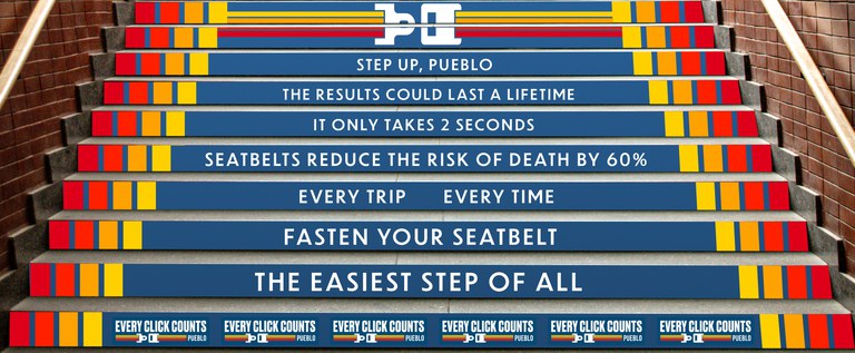 A rendering depicting an outdoor stairway where colorful strips have been applied to the side of each step. Each strip includes a message. 