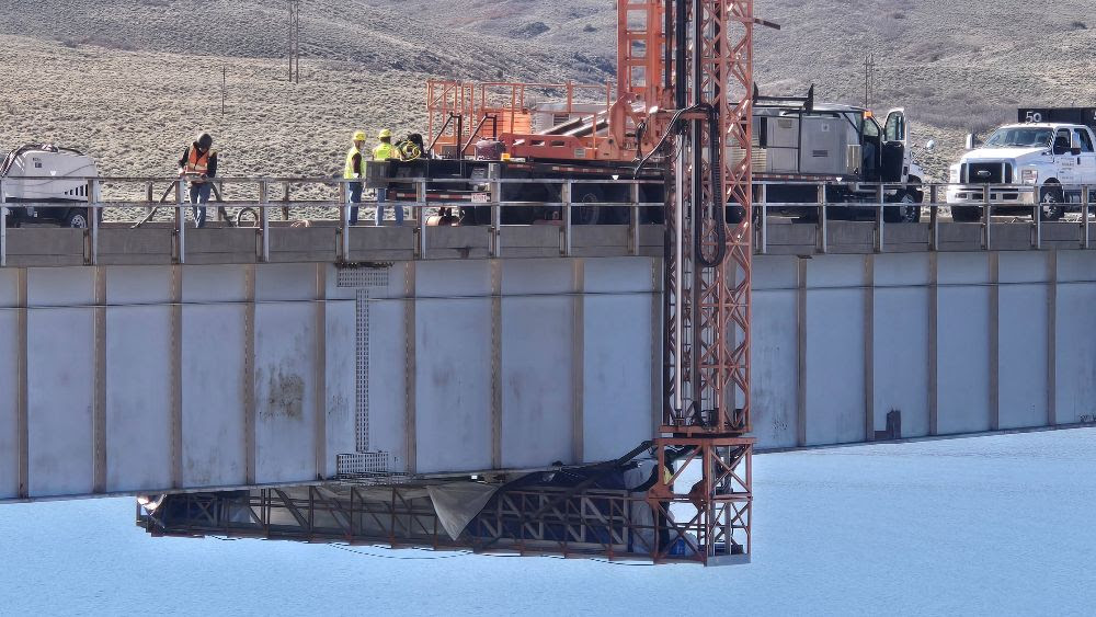 Inspectors are removing paint and conducting ultrasonic testing on the underside of the bridge while tarps prevent debris from falling into the reservoir.jpg detail image