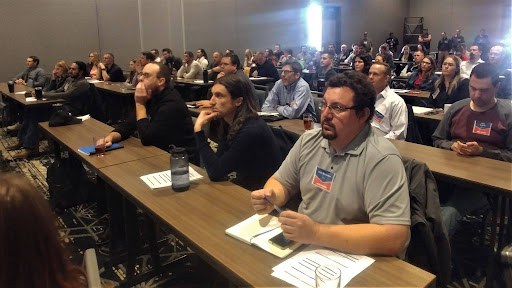 Attendees seated at rows of long tables at the Region 4 Base Course event.