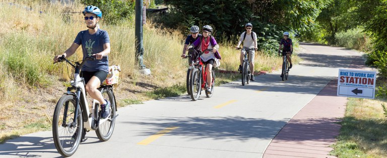 Bicyclists on Trail Five bicyclists ride their bikes along a Denver trail during Bike to Work Day