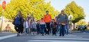 A group of elementary school children and adults walking together across a painted street crosswalk on a sunny day with bright autumn trees and a stop sign in the background. Photo courtesy of Canyon Creek School District. thumbnail image