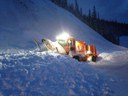 An orange, CDOT snowplow with its headlight on clears snow at night.jpg thumbnail image