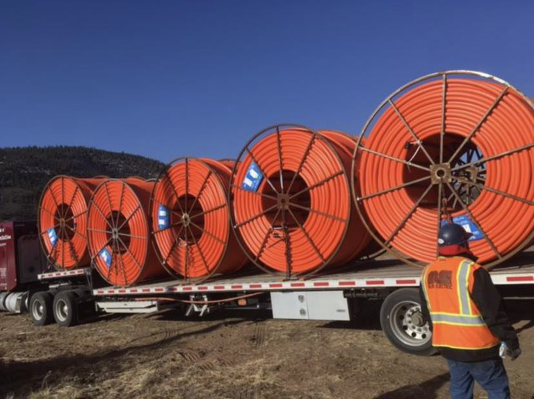 DOT worker alongside a semi truck bed of fiber material