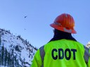 CDOT's specially trained avalanche crew observes avalanche mitigation equipment being transported into place by a helicopter.jpg thumbnail image
