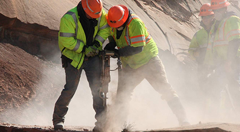 Crews drilling on a rock