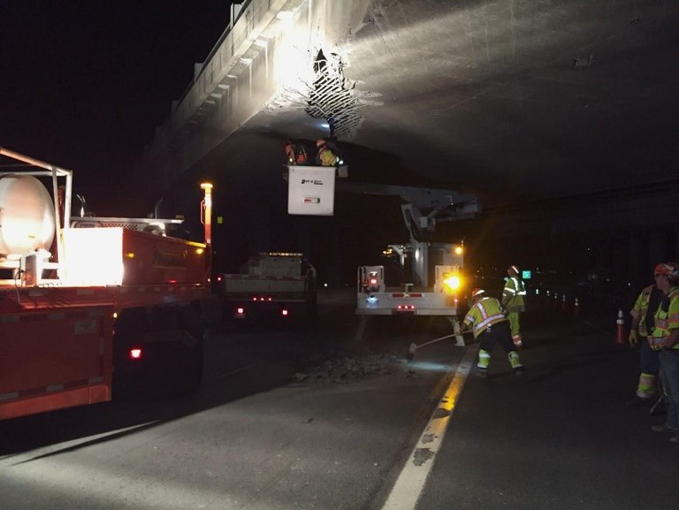 Light shines on a group of CDOT workers maintaining road conditions at night