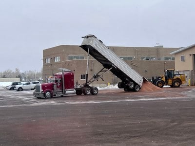 Semi dumping load of sand into parking lot. Semi dumping load of sand into parking lot.