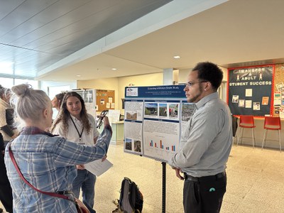 Mike Prado and Eric Linkhart presenting research poster to MSU Denver faculty