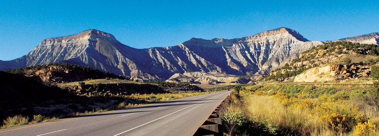 Two lane highway heading into a mountain scenery