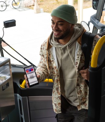 Man getting on bus using cell phone app