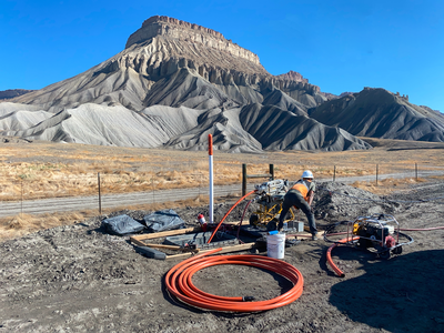 Construction crew installing orange conduit