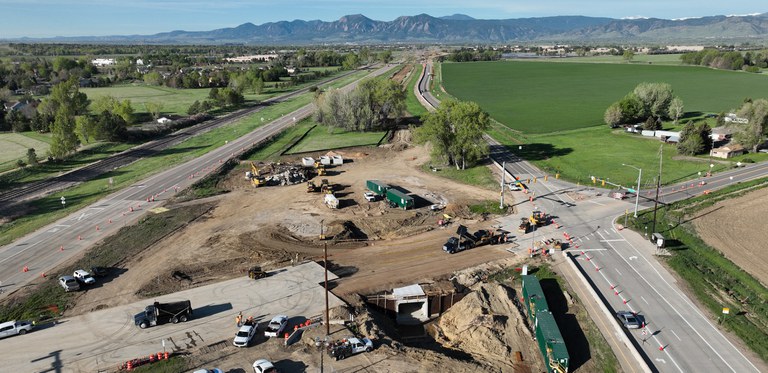 Aerial view of CO 119 work zone facing the Boulder Flatirons. The work zone features large trucks, orange cones and a large dirt area. Aerial view of CO 119 work zone facing the Boulder Flatirons. The work zone features large trucks, orange cones and a large dirt area.