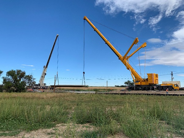 Cranes lifting prepoured bridge deck