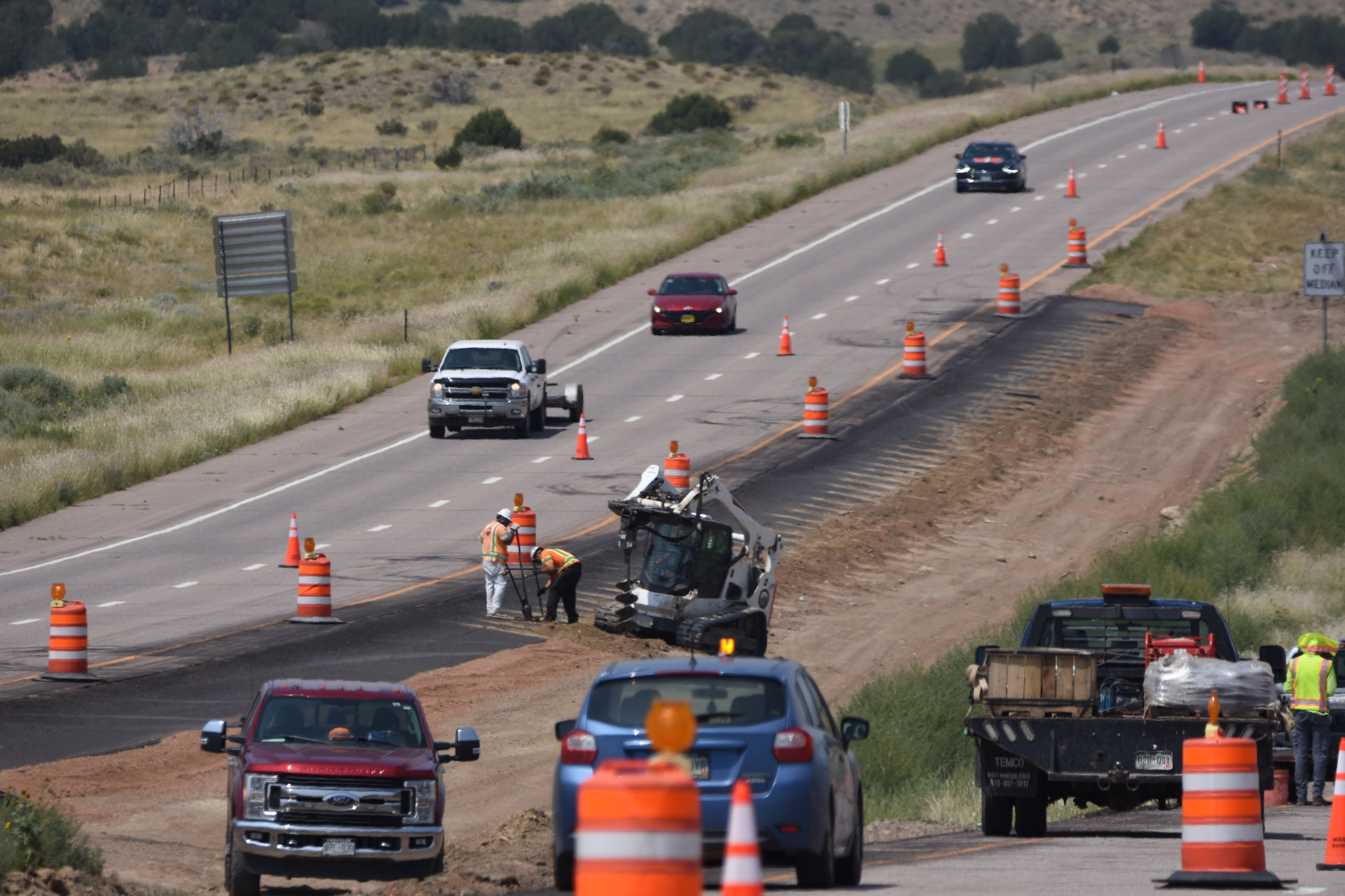 Crews drilling holes for cable rail posts on US 50 west of Penrose.jpg detail image