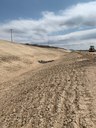This photo was taken from the northbound side of US 85, looking south. This photo shows slopes that have been completed and seeded along with the placement of rock check dams in the roadside ditch. (April 2021 - photo provided by Castle Rock Construction) thumbnail image