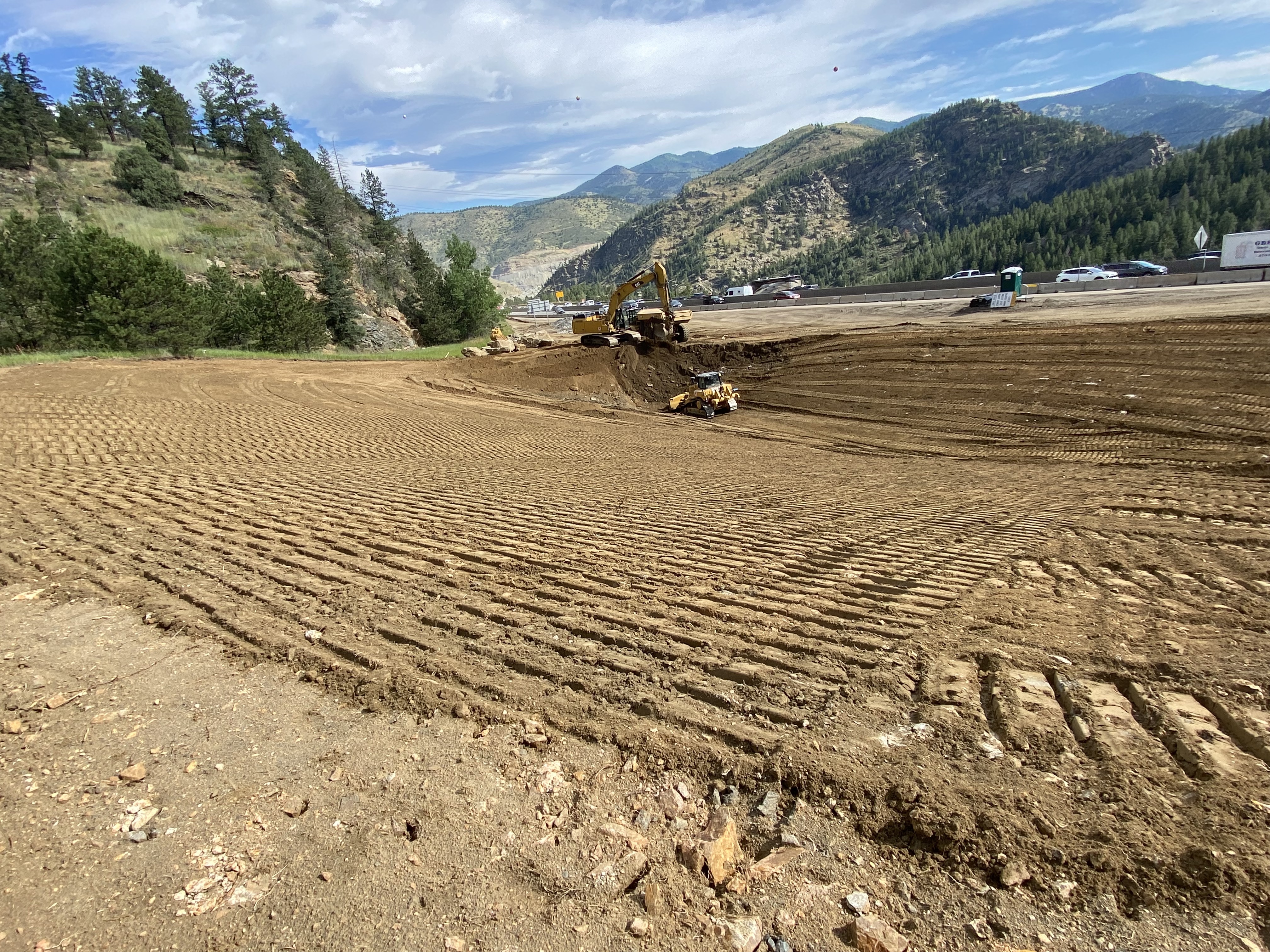 Construction equipment working on grading. | Alt text: Heavy machinery moving dirt. detail image