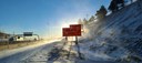 Road sign with blowing snow and bright sun. thumbnail image