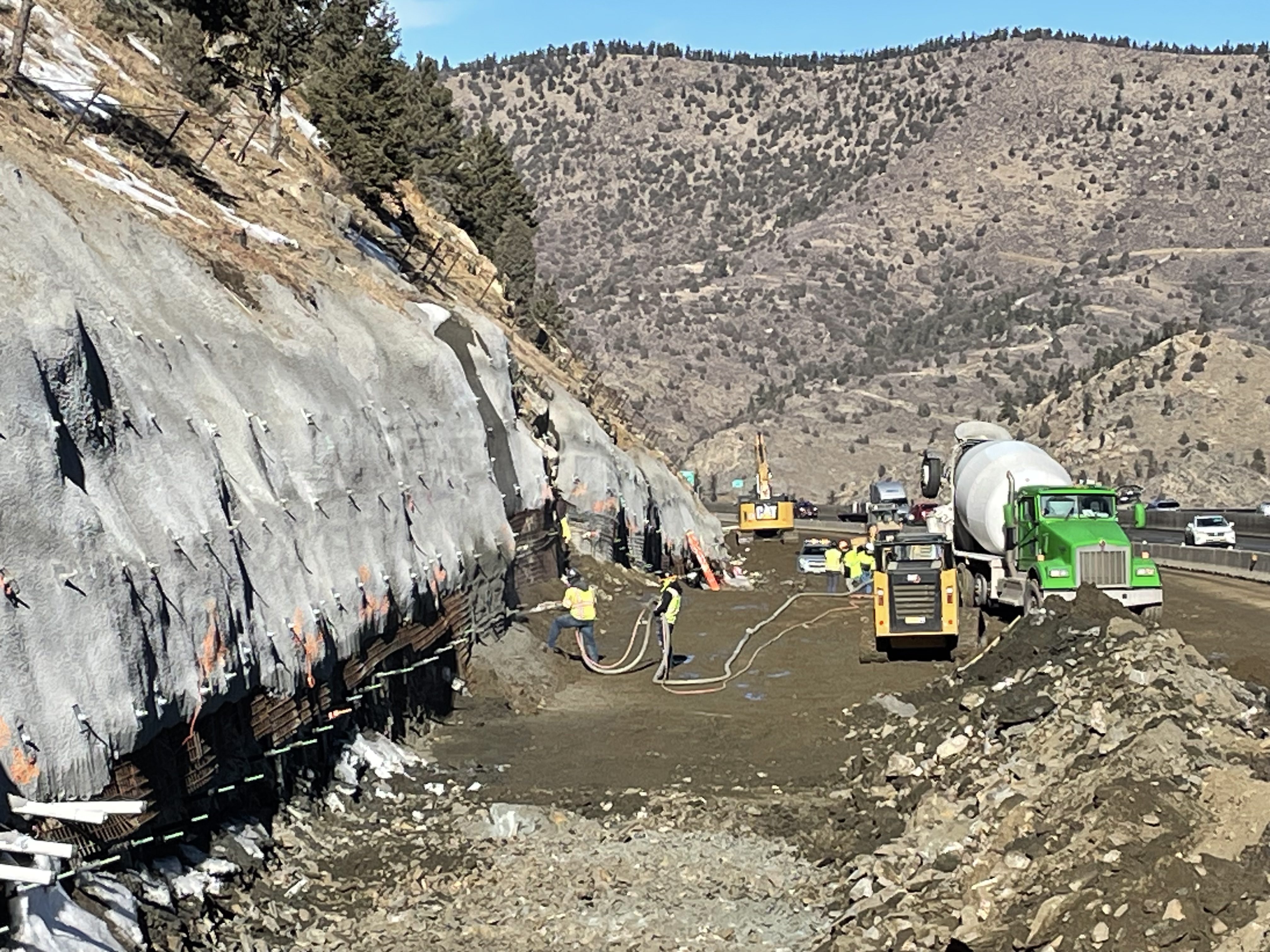 Crews spraying shotcrete on mountain wall. detail image