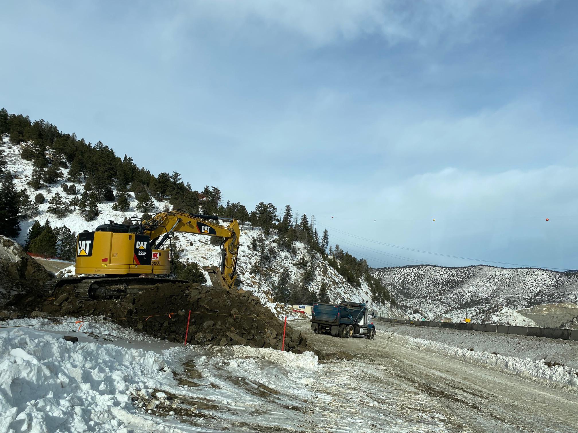 Excavator moving dirt into back of truck. detail image