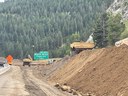 Two pieces of equipment hauling dirt on a hill. thumbnail image