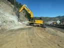 Construction equipment drilling into Floyd Hill wall