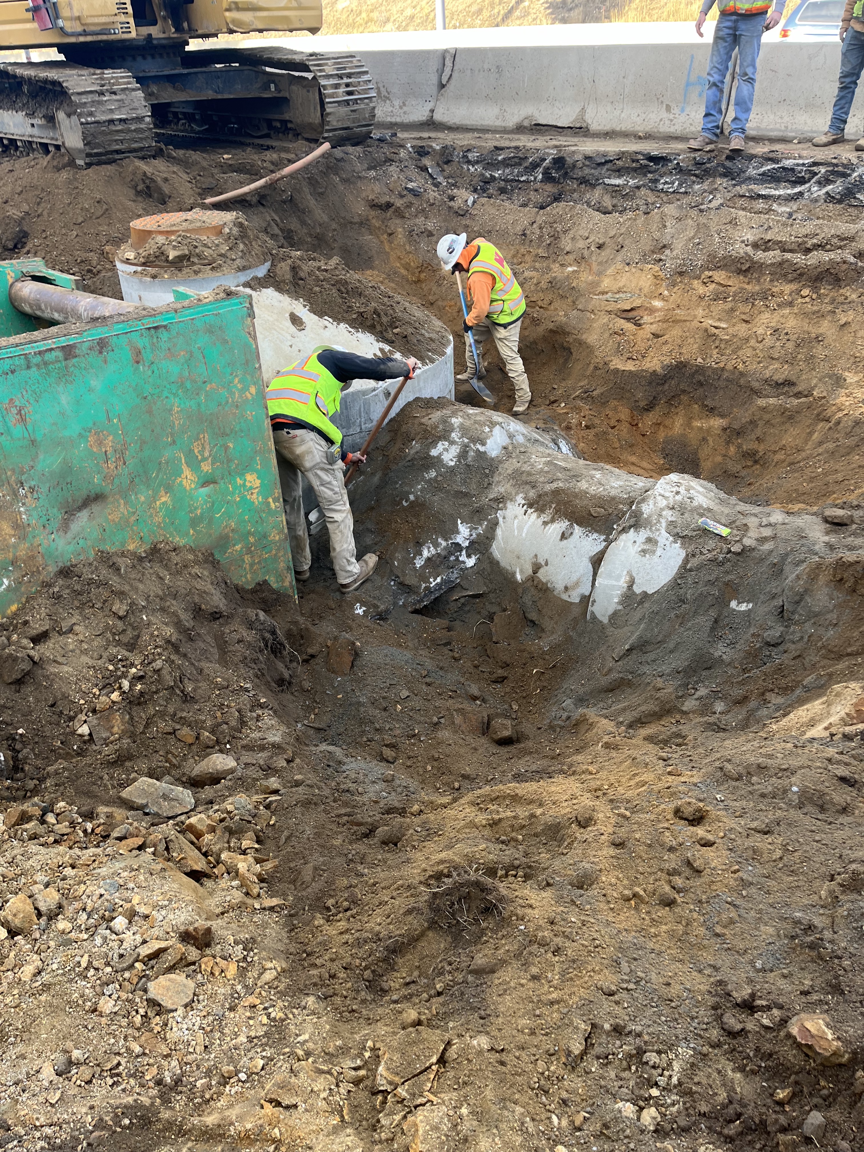 Construction workers digging around large drainage pipe detail image