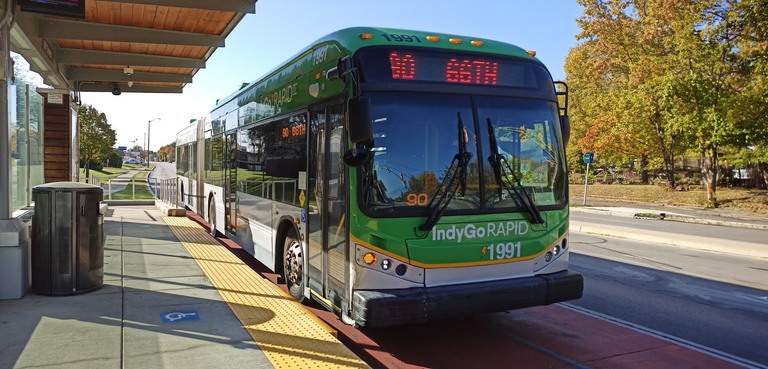 Indy Go Rapid bus rapid transit shelter in Indianapolis, Indiana. The shelter features accessible bus entryways and seating, a canopy and trash receptacles, among other amenities. 
