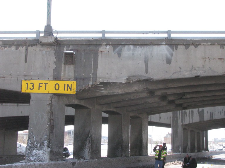 23rd Avenue Bridge with 13 foot 0 inch sign and crew members standing underneath