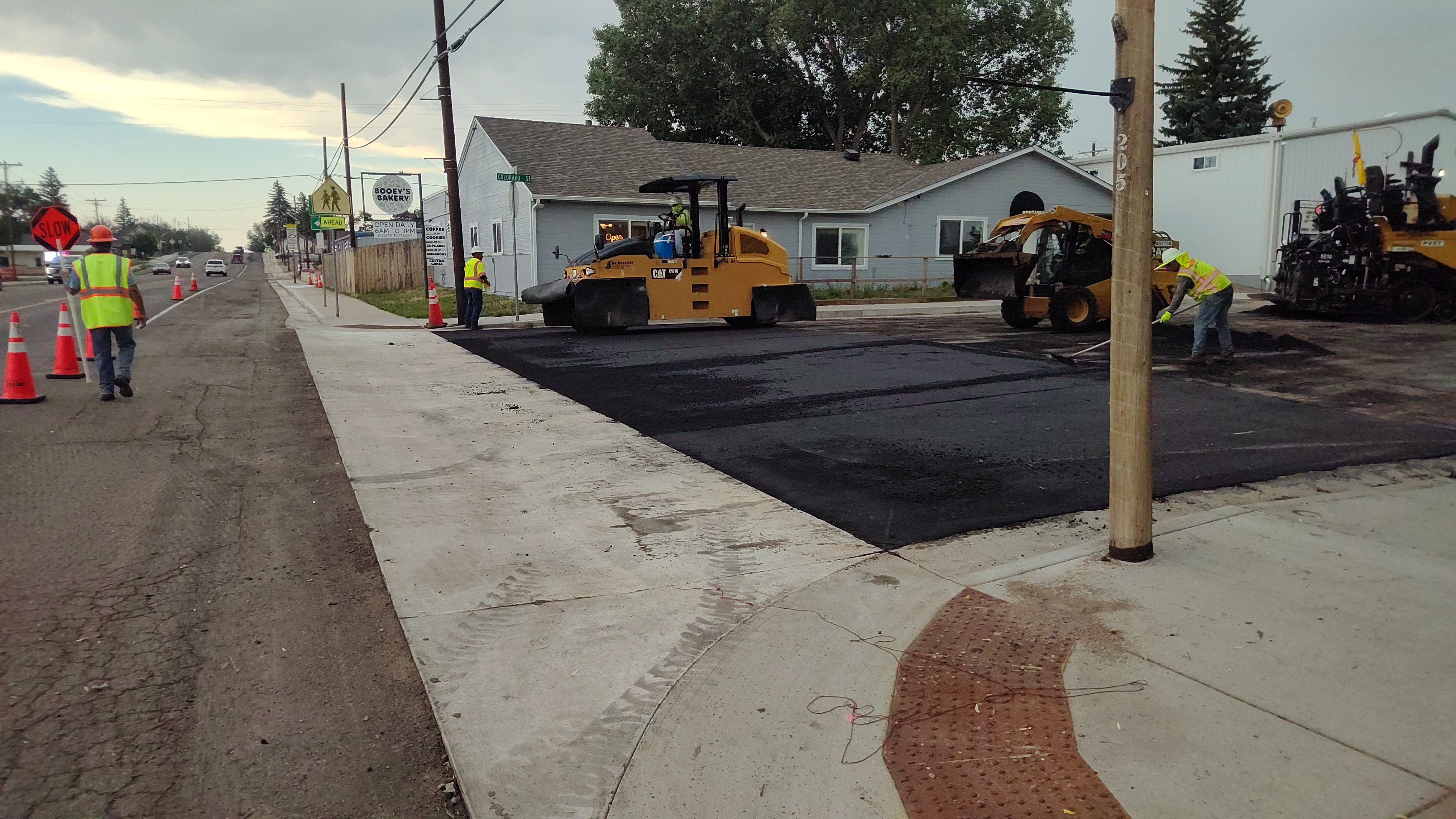 US 24 Resurfacing from Peyton to Calhan - Paving crew patching in the street transition into the newly installed concrete cross pan.jpg detail image