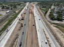 Aerial view looking south along I-25 showing noise wall post installation, highway median earthwork, and active traffic lanes as part of the I-25/US 50B interchange project. thumbnail image