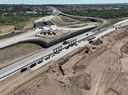 Aerial view of the I-25/US 50B interchange project showing new bridge piers constructed along I-25, with active highway traffic, retaining walls and earthwork in progress. thumbnail image