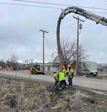 Crews locate gas and water lines on the west side of 20 Road.