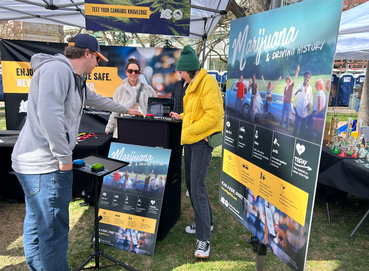 Individuals gathered at the CDOT booth playing trivia game on cannabis and driving.png detail image