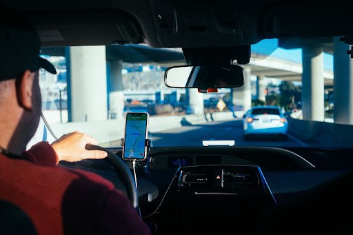 Person using navigation app on their phone while driving.