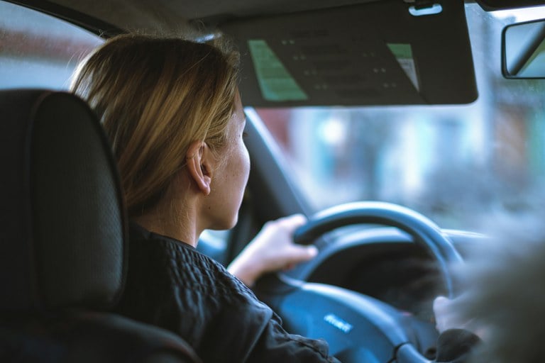 Woman sitting in the driver’s seat of a vehicle.