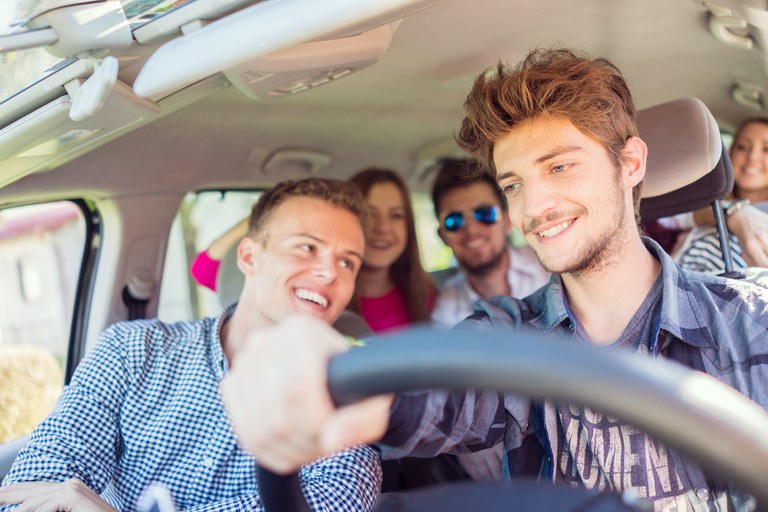 Young adults riding in a car. 