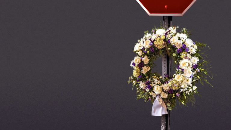 Floral wreath adhered to a stop sign to memorialize traffic deaths in Washington.  
