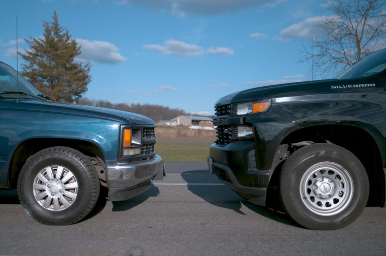 Deadly rise of giant trucks and SUVs An older pickup truck and new pickup truck parked hood-to-hood.