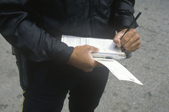 Law enforcement officer writing a traffic citation.