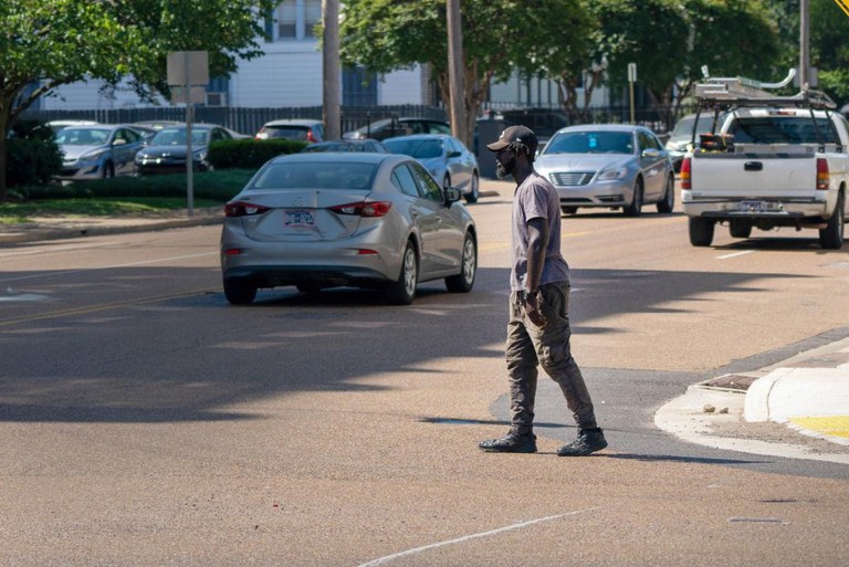 Male walking across busy urban street 