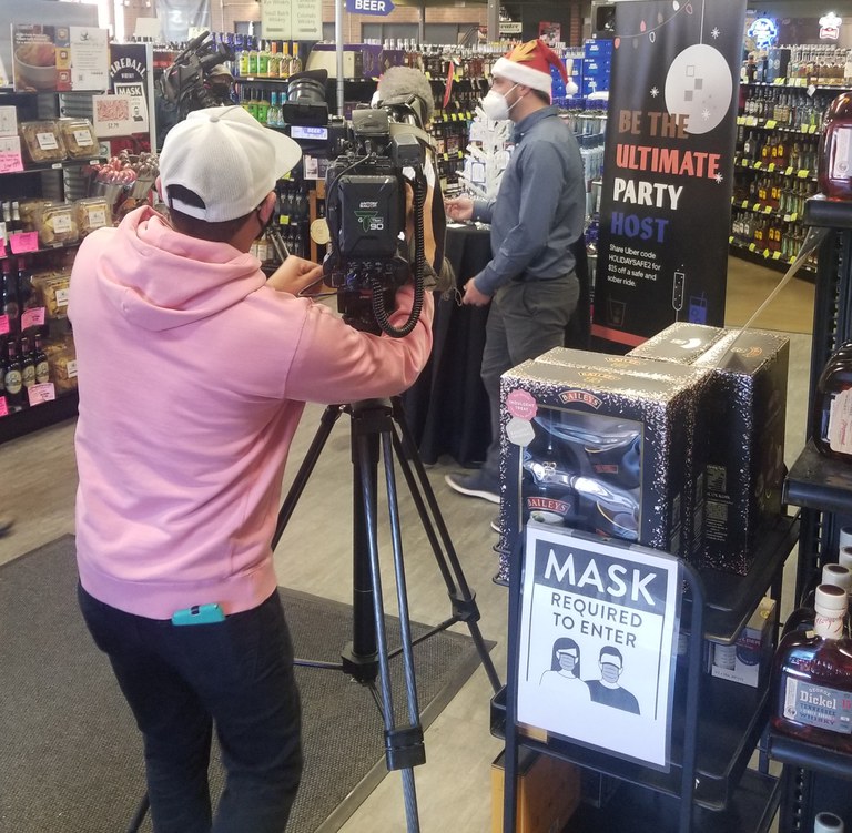 A news crew covers the pop-up event at Argonaut Liquor as CDOT hands out Uber ride credits during the holidays.